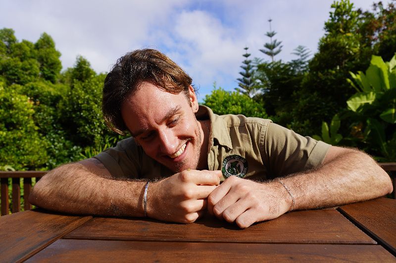Norfolk Island National Park ranger, Sam Burridge with a tiny ‘pearl’ snail on his hand.